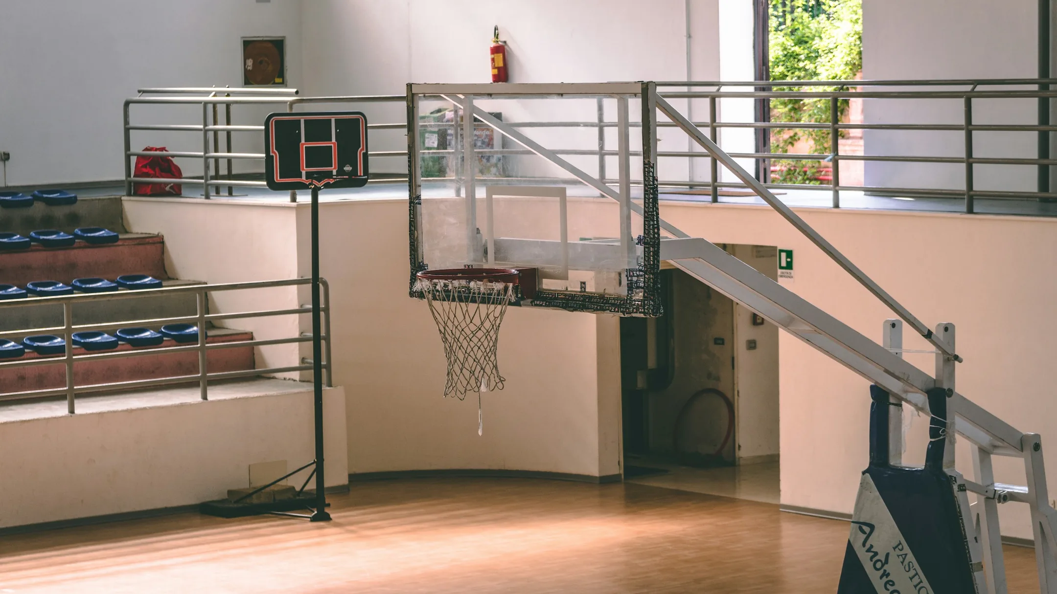 Prázdna telocvičňa s basketbalovými košmi a drevenou podlahou